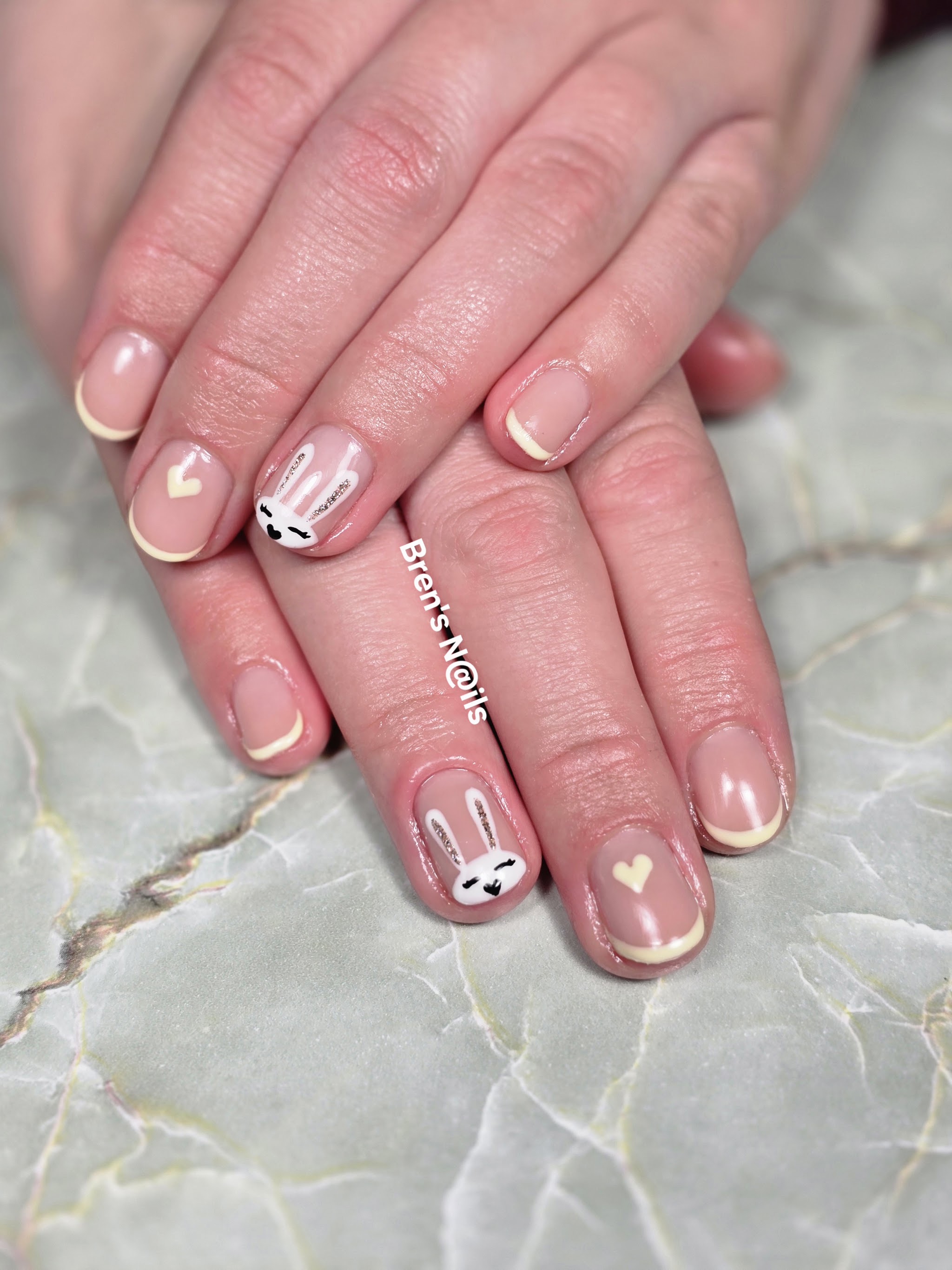 French nagels met een konijntje en hartjes als nail art op grijs marmer